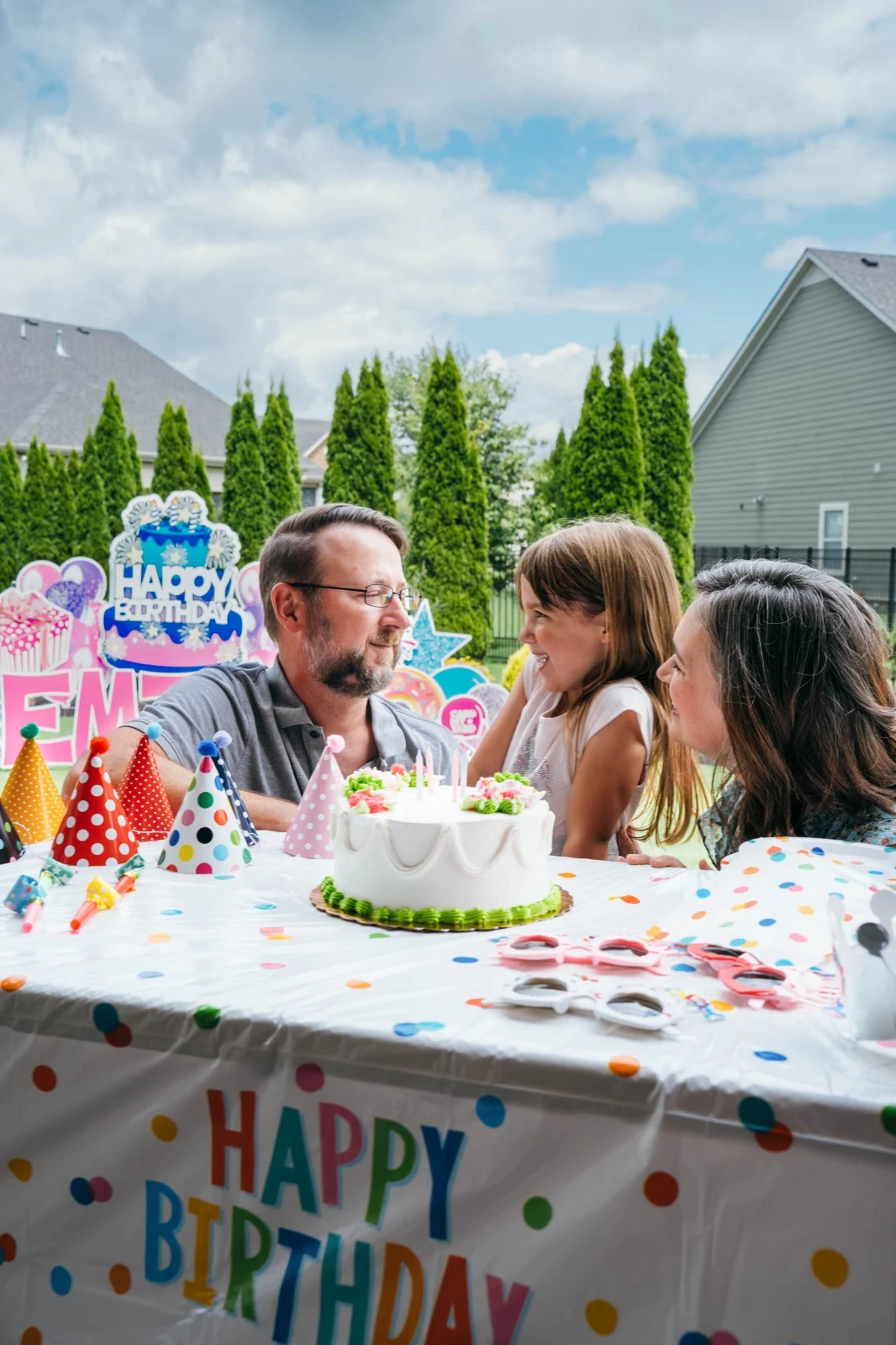 Kids celebrating birthday at party table outdoors